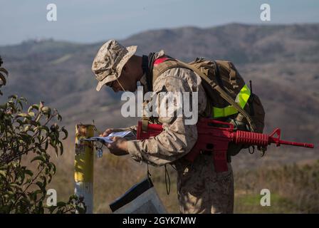 Ein US-Marine-Student mit Grundaufklärungskurs, Advanced Infantry Training Bataillon, School of Infantry - West, lokalisiert einen Punkt während einer Landnavigation als Teil der individuellen Skills-Phase des Kurses auf Marine Corps Base Camp Pendleton, Kalifornien, 15. Januar 2020. Während der Evaluation müssen die Studierenden 50 Meter voneinander entfernt bleiben und zehn Punkte selbstständig finden. BRC vermittelt den Studenten grundlegende Kenntnisse über Aufklärungslehre, Konzepte und Techniken mit Schwerpunkt auf amphibischen Eintritt und Extraktion, Strandaufklärung und Aufklärungspatrouille sk Stockfoto