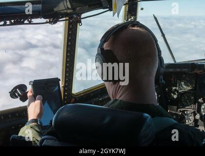 Maj. William Keleher, 118. Airlift Squadron Pilot, überprüft eine Karte im Cockpit eines C-130H Hercules, der dem 103. Airlift Wing während eines lokalen Trainingsfluges über den Westen von Massachusetts am 15. Januar 2020 zugewiesen wurde. Die Flugzeugbesatzungen der 103. Flogen eine zwei-Schiffe-Formation und führten Luftabwürfe mit schweren Paletten und Containerliefersystemen durch, um die wichtigsten taktischen Luftlift-Fähigkeiten zu trainieren. (USA Foto der Air National Guard von Staff Sgt. Steven Tucker) Stockfoto