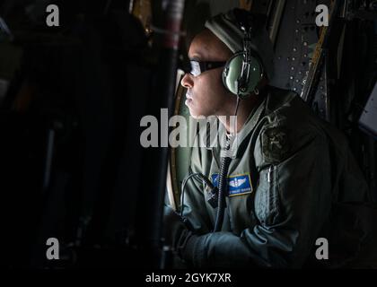 Master-Sgt. Khaleef Graham, 118. Airlift Squadron Ladermaster, blickt aus dem Fenster eines C-130H Hercules, der dem 103. Airlift Wing während eines lokalen Trainingsfluges über den Westen von Massachusetts, Januar 15, zugewiesen wurde. 2020. Die Luftbesatzungen flogen eine zwei-Schiffe-Formation und führten Luftabwürfe mit schweren Paletten und Containerlieferungssystemen durch, um die wichtigsten taktischen Luftlift-Fähigkeiten zu trainieren. (USA Foto der Air National Guard von Staff Sgt. Steven Tucker) Stockfoto