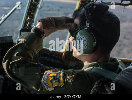 Maj. Doug Ferro, 118. Airlift Squadron Pilot, blickt vom Cockpit eines C-130H Hercules, der dem 103. Airlift-Flügel zugewiesen wurde, auf den Flugplatz der Westover Air Reserve Base, Chicopee, Mass., 15. Januar 2020. Die Flugzeugbesatzungen der 103. Flogen eine zwei-Schiffe-Formation und führten Luftabwürfe mit schweren Paletten und Containerliefersystemen durch, um die wichtigsten taktischen Luftlift-Fähigkeiten zu trainieren. (USA Foto der Air National Guard von Staff Sgt. Steven Tucker) Stockfoto