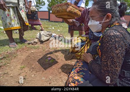 Palu, Indonesien. Okt. 2021. Ein Hindu schreit, als er einen Behälter als Ort der Geister der Familien derer bestatbt, die bei einer Massenverbrennungszeremonie im Prajapati Tempel, Palu City, Zentral-Sulawesi, starben. Das Ritual umfasste 36 Leichen, darunter Covid-19 Opfer, die zuvor verbrannt und begraben worden waren. Dabei werden die Geister derer, die gestorben sind, wieder auferstehen und beten erneut, dass sie gut aufgenommen werden, bevor Ida Sang Hyang Widhi Wasa (allmächtiger Gott). (Foto: Adi Pranata/Pacific Press) Quelle: Pacific Press Media Production Corp./Alamy Live News Stockfoto