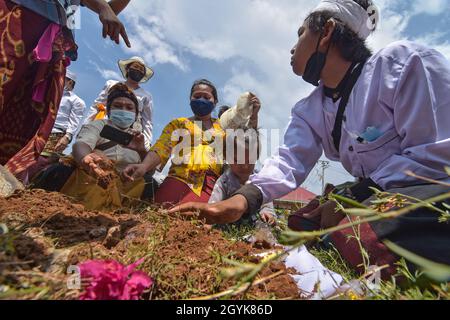 Palu, Indonesien. Okt. 2021. Hindus begraben den Container der Verkörperung, in dem die Geister ihrer Familien, die bei der ngaben ngedet Zeremonie oder Massenverbrennung im Prajapati Tempel, Palu City, Zentral-Sulawesi, starben. Das Ritual umfasste 36 Leichen, darunter Covid-19 Opfer, die zuvor verbrannt und begraben worden waren. Dabei werden die Geister derer, die gestorben sind, wieder auferstehen und beten erneut, dass sie gut aufgenommen werden, bevor Ida Sang Hyang Widhi Wasa (allmächtiger Gott). (Foto: Adi Pranata/Pacific Press) Quelle: Pacific Press Media Production Corp./Alamy Live News Stockfoto