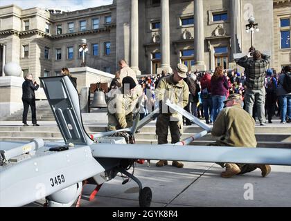 Mitglieder des 116th Brigade Engineer Bataillons der Idaho Army National Guard schließen die Montage eines unbemannten RQ-7B Shadow-Flugzeugs ab, während die Studenten am fünften jährlichen Idaho STEM Matters Day eintreffen. Zu den Betreuern und Betreibern des Überwachungsfahrzeugs kamen verschiedene andere Mitglieder der Idaho Military Division, die die Veranstaltung unterstützten, indem sie die AUSRÜSTUNG und Karrieren IM ZUSAMMENHANG MIT DEM VORBAU der Organisation vorstellten. Stockfoto