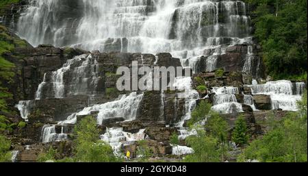 Voss, Hordaland, Norwegen. Wasserfall Tvindefossen Im Frühling. Junge Kaukasische Frau Dame Tourist Traveler Walking Besuch Höchsten Wasserfall Von Norwegen Stockfoto