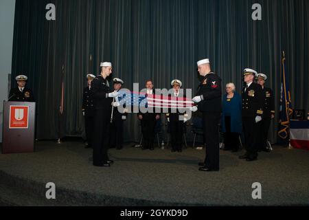 KEYPORT, Washington (Jan 17, 2020) Matrosen, die dem Schnellangriffs-U-Boot USS Pittsburgh (SSN 720) der Los Angeles-Klasse zugewiesen wurden, falten während einer Inaktivierungszeremonie im U.S. Naval Undersea Museum in Keyport, Washington, am 17. Januar, den Fähnrich des Bootes. Pittsburgh und ihre Crew machten ihren ersten arktischen Transit für einen letzten Heimnetzwechsel von Groton, Connecticut, nach Bremerton, Washington, der am 28. Mai eintraf, 2019 um den Inaktivierungs- und Stilllegungsprozess zu starten. (USA Navy Foto von Mass Communication Specialist 1st Class Andrea Perez/veröffentlicht) Stockfoto