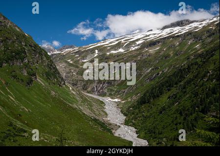 Fluss und Gletscher in den österreichischen Alpen (bei Großvenediger) am sommerblauen Himmel Stockfoto