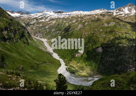 Fluss und Gletscher in den österreichischen Alpen (bei Großvenediger) am sommerblauen Himmel Stockfoto