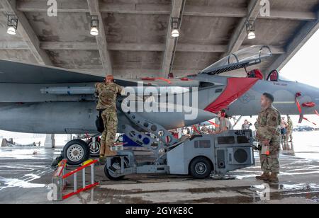 Während des jährlichen Waffenlastwettbewerbs auf der Kadena Air Base, Japan, am 17. Januar 2020, befestigen Mitglieder der Ladungscrew der US-Luftwaffe der 67. Flugzeugwartungseinheit eine AIM-120-Flugrakete mit mittlerer Reichweite an einem F-15C-Adler. Bei diesem Event handelt es sich um einen Verladewettbewerb zwischen Waffenlader-Mannschaften vom 44. Und 67. AMU. Jedes Jahr kämpft das Top-Team der Waffenlader aus jedem Quartal um den jährlichen Titel der Waffenlader-Crew des Jahres. (USA Luftwaffe Foto von Naoto Anazawa) Stockfoto