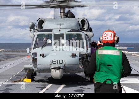 ATLANTISCHER OZEAN (Jan 18, 2020) der Flugbegleiter Michael Collazo aus Tampa, Florida, der den „Tridenten“ des Helicopter Sea Combat Squadron (HSC) 9 zugewiesen wurde, sendet während des Flugbetriebs Signale an einen MH-60S Sea Hawk Helicopter auf dem Flugdeck der USS Gerald R. Ford (CVN 78). Ford führt derzeit Flugzeugkompatibilitätstests durch, um seine elektromagnetischen Flugzeugstartsysteme (EMALS) und Advanced Arresting Gear (AAG) weiter zu testen. (USA Navy Foto von Mass Communication Specialist Seaman Apprentice Angel Jaskuloski) Stockfoto