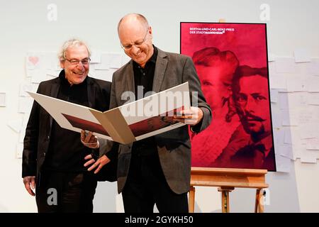 Mannheim, Deutschland. Okt. 2021. Die Preisträger Andreas Knie (l.) und Adalbert Canzler halten ihre Urkunden bei der Preisverleihung des Bertha- und Carl-Benz-Preises in der Kunsthalle Mannheim. Die Mobilitätsforscher Andreas Knie und Adalbert Canzler erhalten den Preis, der mit 10,000 Euro dotiert und alle zwei Jahre vergeben wird. Quelle: Uwe Anspach/dpa/Alamy Live News Stockfoto