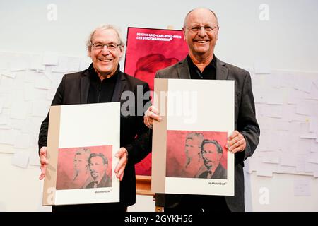 Mannheim, Deutschland. Okt. 2021. Die Preisträger Andreas Knie (l.) und Adalbert Canzler halten ihre Urkunden bei der Preisverleihung des Bertha- und Carl-Benz-Preises in der Kunsthalle Mannheim. Die Mobilitätsforscher Andreas Knie und Adalbert Canzler erhalten den Preis, der mit 10,000 Euro dotiert und alle zwei Jahre vergeben wird. Quelle: Uwe Anspach/dpa/Alamy Live News Stockfoto