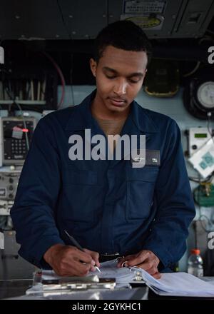 200119-N-AG490-2018 ATLANTIK (JAN 19, 2020) Quartermaster Seaman Apprentice Anthony Hill, der dem Ticonderoga-Klasse Lenkraketen-Kreuzer USS San Jacinto (CG 56) zugeordnet ist, schreibt im Decklog auf der Schiffsbrücke. San Jacinto führt Operationen im Atlantischen Ozean als Teil der USS Dwight D. Eisenhower Carrier Strike Group durch. (USA Navy Photo von Mass Communication Specialist 2nd Class Maxwell Anderson/veröffentlicht) Stockfoto