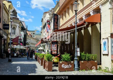 Bukarest, Rumänien - 6. Mai 2021: Alte Gebäude mit Bars und Restaurants in der Lipscani Straße (Strada Lipscani) im historischen Zentrum (Centrul Vechi) Stockfoto