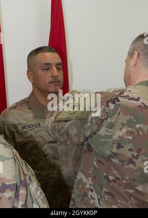 Brig. General Howard Geck, stellvertretender Generalkommandant, Operational Command Post, 1st Theatre Sustainment Command (TSC), stiftet eine Ehrenmedaille der Armee auf Sgt. Beni Mendoza, 33. Quartermaster-Abteilung (QM DET), während der Preisverleihung am Ende der Tour im Camp Arifjan, Kuwait, am 21. Januar 2020. Das 320. QM-DET, das als Subarea Petroleum Office im Support Operations, 1st TSC OCP, diente, wird Anfang Februar neu eingesetzt. (USA Armeefoto von Meister Sgt. Jonathan Wiley) Stockfoto