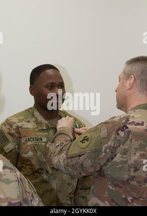 Brig. General Howard Geck, stellvertretender Generalkommandant, Operational Command Post, 1st Theatre Sustainment Command (TSC), stiftet eine Ehrenmedaille der Armee auf Staff Sgt. Daryl Jackson, 33. Quartermaster Detachment (QM DET), während einer Abschlussfeier der Tour im Camp Arifjan, Kuwait, am 21. Januar 2020. Das 320. QM-DET, das als Subarea Petroleum Office im Support Operations, 1st TSC OCP, diente, wird Anfang Februar neu eingesetzt. (USA Armeefoto von Meister Sgt. Jonathan Wiley) Stockfoto