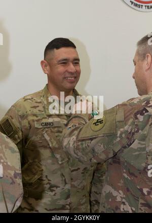 Brig. General Howard Geck, stellvertretender Generalkommandant, Operational Command Post, 1st Theatre Sustainment Command (TSC), stiftet eine Ehrenmedaille der Armee auf Sgt. 1. Klasse Jesus Cano, 33. Quartermaster-Abteilung (QM DET), während einer Abschlussfeier der Tour im Camp Arifjan, Kuwait, 21. Januar 2020. Das 320. QM-DET, das als Subarea Petroleum Office im Support Operations, 1st TSC OCP, diente, wird Anfang Februar neu eingesetzt. (USA Armeefoto von Meister Sgt. Jonathan Wiley) Stockfoto