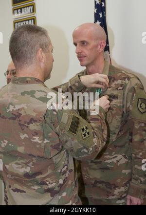 Brig. General Howard Geck, stellvertretender Generalkommandant, Operational Command Post, 1st Theatre Sustainment Command (TSC), stiftet eine Ehrenmedaille der Armee auf Master Sgt. David Branning, 33. Quartermaster Detachment (QM DET), während einer Abschlussfeier der Tour im Camp Arifjan, Kuwait, am 21. Januar 2020. Das 320. QM-DET, das als Subarea Petroleum Office im Support Operations, 1st TSC OCP, diente, wird Anfang Februar neu eingesetzt. (USA Armeefoto von Meister Sgt. Jonathan Wiley) Stockfoto