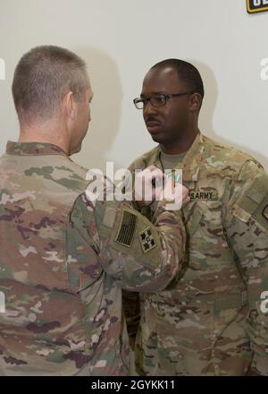 Brig. General Howard Geck, stellvertretender Generalkommandant, Operational Command Post, 1. Theater Sustainment Command (TSC), stiftet während einer Abschlusszeremonie im Camp Arifjan, Kuwait, am 21. Januar 2020, eine Ehrenmedaille der Armee auf Kapitän Khry Abdullah, die 33. Quartermaster-Abteilung (QM DET). Das 320. QM-DET, das als Subarea Petroleum Office im Support Operations, 1st TSC OCP, diente, wird Anfang Februar neu eingesetzt. (USA Armeefoto von Meister Sgt. Jonathan Wiley) Stockfoto