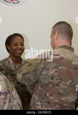 Brig. General Howard Geck, stellvertretender Generalkommandant, Operational Command Post, 1st Theatre Sustainment Command (TSC), stiftet eine Ehrenmedaille der Armee auf Sgt. 1. Klasse Nicole Smith, 21. Quartermaster Detachment (QM DET), während einer Abschlussfeier der Tour im Camp Arifjan, Kuwait, 2020. Januar. Das 320. QM-DET, das als Subarea Petroleum Office im Support Operations, 1st TSC OCP, diente, wird Anfang Februar neu eingesetzt. (USA Armeefoto von Meister Sgt. Jonathan Wiley) Stockfoto