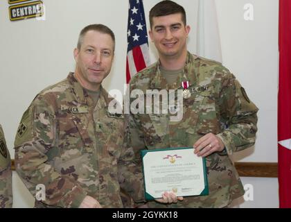 Brig. General Howard Geck, stellvertretender Generalkommandant, Operational Command Post, 1st Theatre Sustainment Command (TSC), posiert mit Kapitän Kyle Whalen, der 33. Quartermaster-Abteilung, nachdem er ihm während einer Abschlussfeier der Tour im Camp Arifjan, Kuwait, am 21. Januar 2020 eine Verdienstmedaille überreicht hatte. Das 320. QM-DET, das als Subarea Petroleum Office im Support Operations, 1st TSC OCP, diente, wird Anfang Februar neu eingesetzt. (USA Armeefoto von Meister Sgt. Jonathan Wiley) Stockfoto