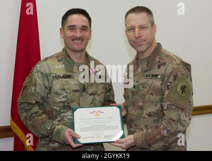 Brig. General Howard Geck, stellvertretender Generalkommandant, Operational Command Post, 1st Theatre Sustainment Command (TSC), posiert mit Sgt. Patrick Salazar der 1. Klasse, nachdem er ihm während einer Abschlussfeier der Tour im Camp Arifjan, Kuwait, am 21. Januar 2020 eine Verdienstmedaille überreicht hatte. Das 320. QM-DET, das als Subarea Petroleum Office im Support Operations, 1st TSC OCP, diente, wird Anfang Februar neu eingesetzt. (USA Armeefoto von Meister Sgt. Jonathan Wiley) Stockfoto