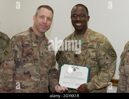 Brig. General Howard Geck, stellvertretender Generalkommandant, Operational Command Post, 1st Theatre Sustainment Command (TSC), posiert mit Capt. Khry Abdullah, 320. Quartermaster Detachment (QM DET), nachdem er ihm während einer Abschlussfeier der Tour im Camp Arifjan, Kuwait, am 21. Januar 2020 eine Ehrenmedaille der Armee überreicht hatte. Das 320. QM-DET, das als Subarea Petroleum Office im Support Operations, 1st TSC OCP, diente, wird Anfang Februar neu eingesetzt. (USA Armeefoto von Meister Sgt. Jonathan Wiley) Stockfoto