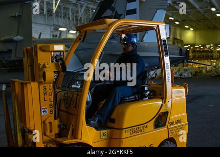 ATLANTISCHER OZEAN (Jan 21, 2020) Aviation Support Equipment Technician 2nd Class Juan Hernandez aus New York, der der Zwischeninstandhaltungsabteilung der Flugzeuge von USS Gerald R. Ford (CVN 78) zugewiesen wurde, fährt einen Gabelstapler in die Hangarbucht des Schiffes. Techniker von Aviation Support Equipment betreiben, warten, reparieren und testen elektrische Fahrzeugsysteme in Bodengeräten. Ford führt derzeit Flugzeugkompatibilitätstests durch, um seine elektromagnetischen Flugzeugstartsysteme (EMALS) und Advanced Arresting Gear (AAG) weiter zu testen. (USA Navy Foto von Mass Communication Specialist Seaman Jesus O. AGUI Stockfoto