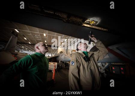 200121-N-YQ383-1121 (Jan 21, 2020) Mate Aaron M. Plumb, Chief Aviation Electrician, aus Ashburn, VA., und Joshua K. McWilliams, 2. Klasse der Luftfahrtstrukturmechanik, aus Ripley, Tennessee, Inspizieren Sie den Hohlraum einer Vorderkante der Klappe an einer F/A-18E Super Hornet, die den „Blauen Diamanten“ des Strike Fighter Squadron (VFA) 146 in der Hangarbucht des Flugzeugträgers USS Theodore Roosevelt (CVN 71) am 21. Januar 2020 zugewiesen wurde. Die Theodore Roosevelt Carrier Strike Group ist im Indo-Pazifik-Raum im Einsatz. (USA Navy Foto von Mass Communication Specialist 3rd Class Brandon Richardson) Stockfoto