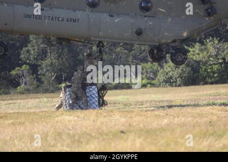 Ein Flieger der 820. Base Defense Group verbindet eine Kiste mit einem CH-47 Chinook während des Pathfinder-Kurses am 23. Januar 2020 in der Lightning Academy, Hawaii. Die U.S. Army Pathfinder School soll den Schülern die Fähigkeiten vermitteln, sich durch fremdes Gelände zu navigieren und sichere Landezonen einzurichten. Stockfoto