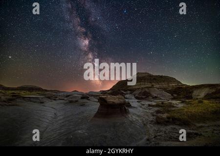 Die Sommer-Milchstraße und die galaktische Kernregion über den Formationen im Dinosaur Provincial Park, Alberta, am 9. Juli 2021, in einer warmen mondlosen Nacht. Dies Stockfoto