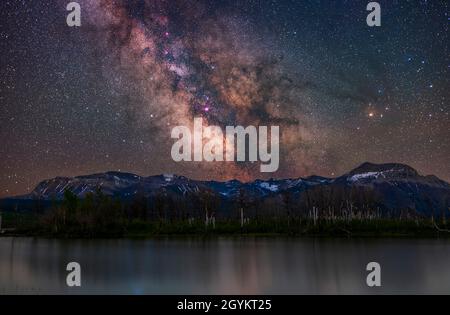 Die galaktische Kernregion der Milchstraße über Maskinonge Pond und Sofa Mountain im Waterton Lakes National Park, Alberta, in einer frühen Juninacht. Scor Stockfoto