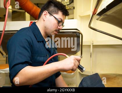 ATLANTISCHER OZEAN (Jan 24, 2020) der Seaman William Hunter aus Lebanon, Tennessee, der Versorgungsabteilung von USS Gerald R. Ford (CVN 78) zugewiesen wurde, sprüht Wasser auf die Overalls zur Dampfreinigung in Fords Waschraum. Ford führt derzeit Kompatibilitätstests für Flugzeuge durch. (USA Navy Foto von Mass Communication Specialist Seaman Zack Guth) Stockfoto