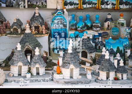 Gruppe von schönen Trulli Souvenirs, traditionelle Apulian Trockenmauer Hütte alten Häusern mit einem kegelförmigen Dach in Alberobello, Apulien, Italien Stockfoto