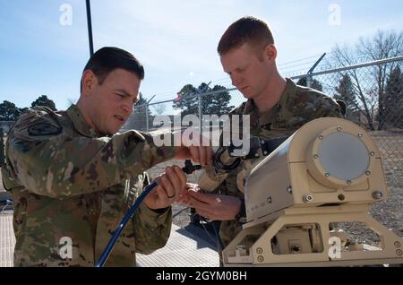 Master-Sgt. Steven Edmon, Flugchef des 25th Space Range Squadron Mission Assurance Operations, Left und Tech. Sgt. Ryan Seamster, Leiter der 25. SRS-Kommunikationszentrale, installiert eine K-Under-Versorgung auf einer bodenweiten Multi-Band-Terminal-Antenne in ihrem Lager, Colorado Springs, Colorado, am 24. Januar 2020. Das 25th SRS bietet Kunden eine sichere Umgebung, in der sie Schulungen zum Jammen der Satellitenkommunikation für den Kampf gegen eine umkämpfte Umgebung erhalten können. (USA Foto der Luftwaffe von Staff Sgt. Matthew Coleman-Foster) Stockfoto