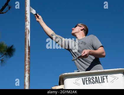 United States Air Force Staff Sgt. Erich Olsen, 325. Maintenance Squadron, Low Observable Maintainer, bringt Primer auf die Spitze eines Fahnenmastes, Panama City, Florida, 25. Januar 2020. Olsen und seine Mitstreiter nutzten ihre Fähigkeiten aus dem Malen von Kampfflugzeugen, um den Fahnenmast der St. Andrew School wiederherzustellen, der nach dem Hirt Michael verrostet wurde. Stockfoto