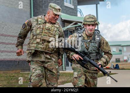 Chief Warrant Officer 4 Phillip Brashear, ein Chief Warrant Officer des US Army Reserve-Kommandos für das 80. Trainingskommando, jubelt über Alexander Matte, einen Warrant Officer-Kandidaten, der das Regional Training Institute besucht, als er sich der Ziellinie eines fußmarsches in Fort Pickett, Virginia, nähert, 25. Januar 2020. Brashear ist ein Hubschrauberpilot mit Kampferfahrung und Sohn von Carl Brashear, dem ersten afroamerikanischen Meistertaucher in der Geschichte der US-Marine, der 1966 bei einem tragischen Unfall auf einer Tauchermission vor der spanischen Küste sein Bein verlor. Carl Brashears Lebensgeschichte über die Überwindung von Physis Stockfoto