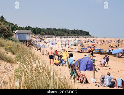 Strandhütten und Toursisten im Sommer Strand Sand Dünenlandschaft von Holkham Strand Wells Next the Sea an der North Norfolk Heritage Coast England Großbritannien Stockfoto