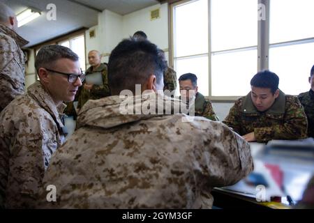 US-Marineinfanteristen vom 1. Bataillon, dem 25. Marine-Regiment, dem 3. Bataillon, dem 12. Marine-Regiment und dem 3. Strafverfolgungsbataillon besprechen die nächsten Trainingsveranstaltungen mit ihren Kollegen der 5. Brigade, Japan Ground Self-Defense Force, während der Übung Northern Viper auf dem Trainingsgebiet Yausubetsu, Hokkaido, Japan, 26. Januar 2020. Northern Viper ist eine regelmäßig geplante Trainingsübung, die die Interoperabilität der US- und Japan-Allianz verbessern soll, indem sie es Marine Air-Ground Task Forces der III Marine Expeditionary Force ermöglicht, ihre Letalität und Kompetenz in MAGTF Combi aufrechtzuerhalten Stockfoto