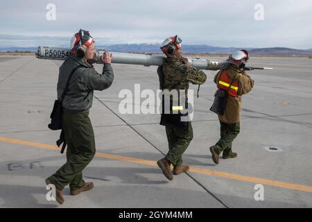 Marines mit Marine Attack Squadron 231 tragen während des Trainings bei kaltem Wetter auf der Naval Air Station Fallon, Nevada, die Kampfwaffe zu einem AV-8B Harrier II 24. 2020 VMA-231 nimmt an Schulungen für kaltes Wetter Teil, um das Gerät besser auf kälteres Klima vorzubereiten und gleichzeitig die Kampfeffizienz zu gewährleisten. (USA Marine Corps Foto von Lance CPL. Steven Walls) Stockfoto