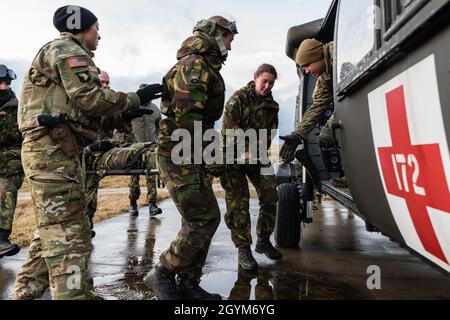 US Army Sgt. 1. Klasse Marcia McNeill, Charlie Company, 2. Bataillon, 3. Kampfluftfahrtbrigade, 3. Infanterie-Division instruiert medizinische Fachkräfte der niederländischen Armee in der richtigen Müllverladetechnik für den HH-60M Blackhawk MEDEVAC Hubschrauber, 28. Januar 2020, im Hohenfels Trainingsgebiet während der kombinierten Auflösung XIII (USA Armeefoto von Sgt. 1. Klasse Garrick W. Morgenweck) Stockfoto