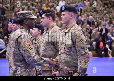 Befehl Sgt. Maj. Jaime Price, nicht beauftragter Offizier-Akademiekommandant, schüttelt sich die Hände mit SPC. Tate Mahar vom 6. Squadron, 8. Kalvarienregiment, 2. Panzerbrigade-Kampfteam, die im Newman Fitness Center in Fort Stewart, Georgia, im Rahmen einer Abschlusszeremonie des Basic Leaders Kurses den Iron Sergeant Award erhielt., Jan. 31. Der Iron Sergeant Award wird an den Soldaten mit dem besten Ergebnis des Physical Fitness Tests verliehen. (USA Army Photo von SPC. Jordyn Worshek) Stockfoto