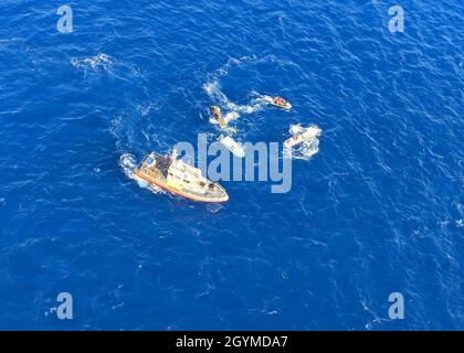 Die Küstenwache und Ocean Safety retteten zwei Bootsfahrer aus ihrem umgedrehten 13-Fuß-Boston-Whaler eine Meile vor Kahoolawe, Hawaii, 31. Januar 2020. Eine 45-Fuß-Crew der Station Maui, die mit einem Boot von mittlerer Größe ausgestattet ist, die Air Station Barbers Point MH-65 Dolphin-Helikopter-Besatzung, die Besatzung des Küstenwache-Schneiders Joseph Gerczak und die Maui Ocean Safety and Lifeguard Services, die Jet-Ski-Betreiber eingesetzt haben, reagierten auf den Vorfall. (USA Foto der Küstenwache von Petty Officer, 3. Klasse, Alex Hutson/veröffentlicht) Stockfoto