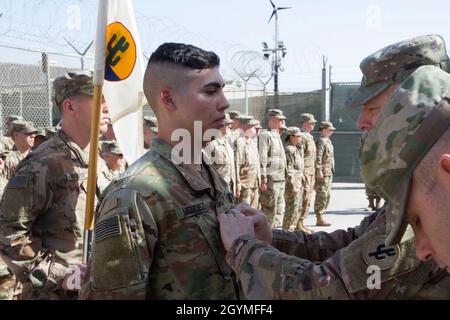 Spc. Fernando Mendez wird von Brig zum Sgt. Befördert. General Howard Geck, kommandierender General, 103. Expeditionary Sustainment Command, während einer Preisverleihung, Patching und Promotion im Camp Arifjan, Kuwait, 2. Februar 2020. (USA Army Reserve Foto von SPC. Dakota Vanidestine) Stockfoto