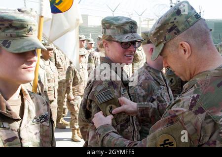 Brig. General Howard Geck, kommandierender General, 103. Expeditionary Sustainment Command (ESC), stellt Sgt. Julie Lautner, 103. ESC, mit einem Kampfpatch während einer Preisverleihung, Patchen und Promotion im Camp Arifjan, Kuwait, 2. Februar 2020. (USA Army Reserve Foto von SPC. Dakota Vanidestine) Stockfoto