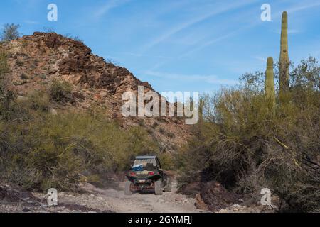 Auf dem Dripping Springs Trail in den Plomosa Mountains in der Nähe von Quartzsite, Arizona, folgt man einem Geländewagen mit Allradantrieb UTV. Stockfoto