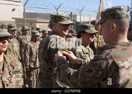 Brig. General Howard Geck, kommandierender General, 103. Expeditionary Sustainment Command (ESC), überreicht Capt. Shelby Peters, 103. ESC, während einer Preisverleihung, Patching und Promotion im Camp Arifjan, Kuwait, am 2. Februar 2020, einen Kampfpatch. (USA Army Reserve Foto von SPC. Dakota Vanidestine) Stockfoto