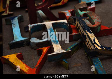Zufällige Sammlung von verwitterten Holzbuchstaben, Zahlen und Zeichen zum Verkauf auf dem Flohmarkt. Stockfoto