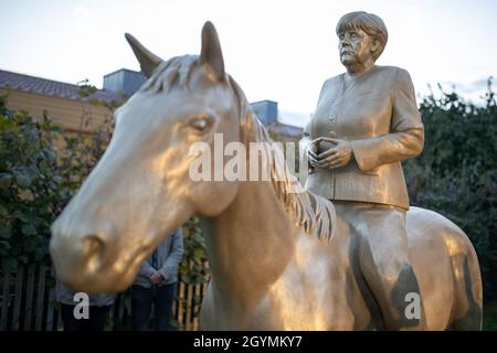 Etsdorf, Deutschland. Okt. 2021. Eine Reiterstatue der noch-Bundeskanzlerin Angela Merkel nach der Enthüllung. Die 2.70 Meter hohe lebensgroße Skulptur wurde aus Leichtbeton und mit einem entsprechenden 3D-Drucker gefertigt. Die Idee kam vom Künstler Wilhelm Koch, der seit Jahrzehnten ungewöhnliche Projekte realisiert, wie ein Luftmuseum mit Skulpturen aus aufgeblasenen Gummischläuchen. Quelle: Daniel Karmann/dpa/Alamy Live News Stockfoto