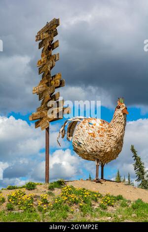 USA, Alaska, Huhn, Metallskulptur, Schild Kilometerpost an Orte, die sich auf Hühner beziehen Stockfoto