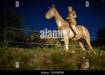 Etsdorf, Deutschland. Okt. 2021. Eine Reiterstatue der noch-Bundeskanzlerin Angela Merkel nach der Enthüllung. Die 2.70 Meter hohe lebensgroße Skulptur wurde aus Leichtbeton und mit einem entsprechenden 3D-Drucker gefertigt. Die Idee kam vom Künstler Wilhelm Koch, der seit Jahrzehnten ungewöhnliche Projekte realisiert, wie ein Luftmuseum mit Skulpturen aus aufgeblasenen Gummischläuchen. Quelle: Daniel Karmann/dpa/Alamy Live News Stockfoto